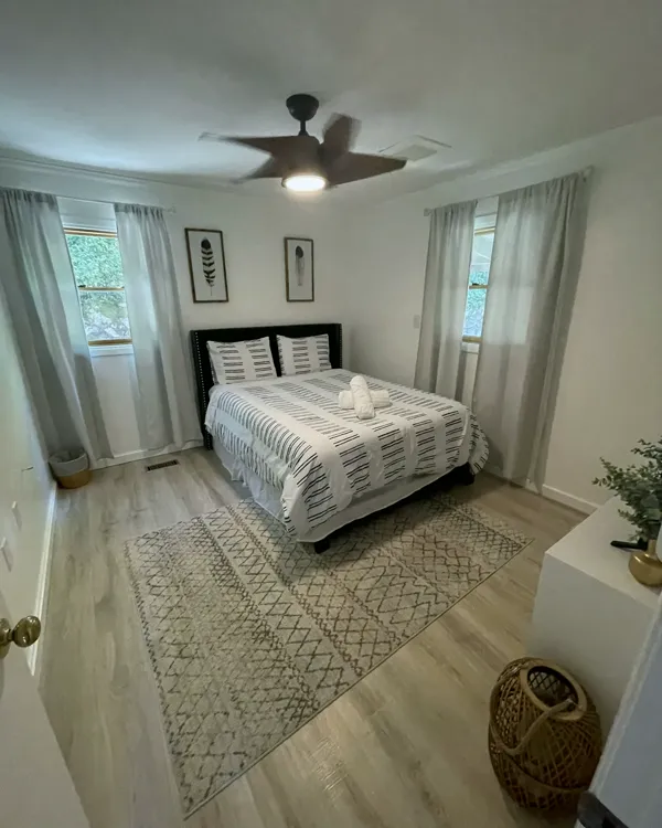 A freshly made guest bed with neatly folded towels