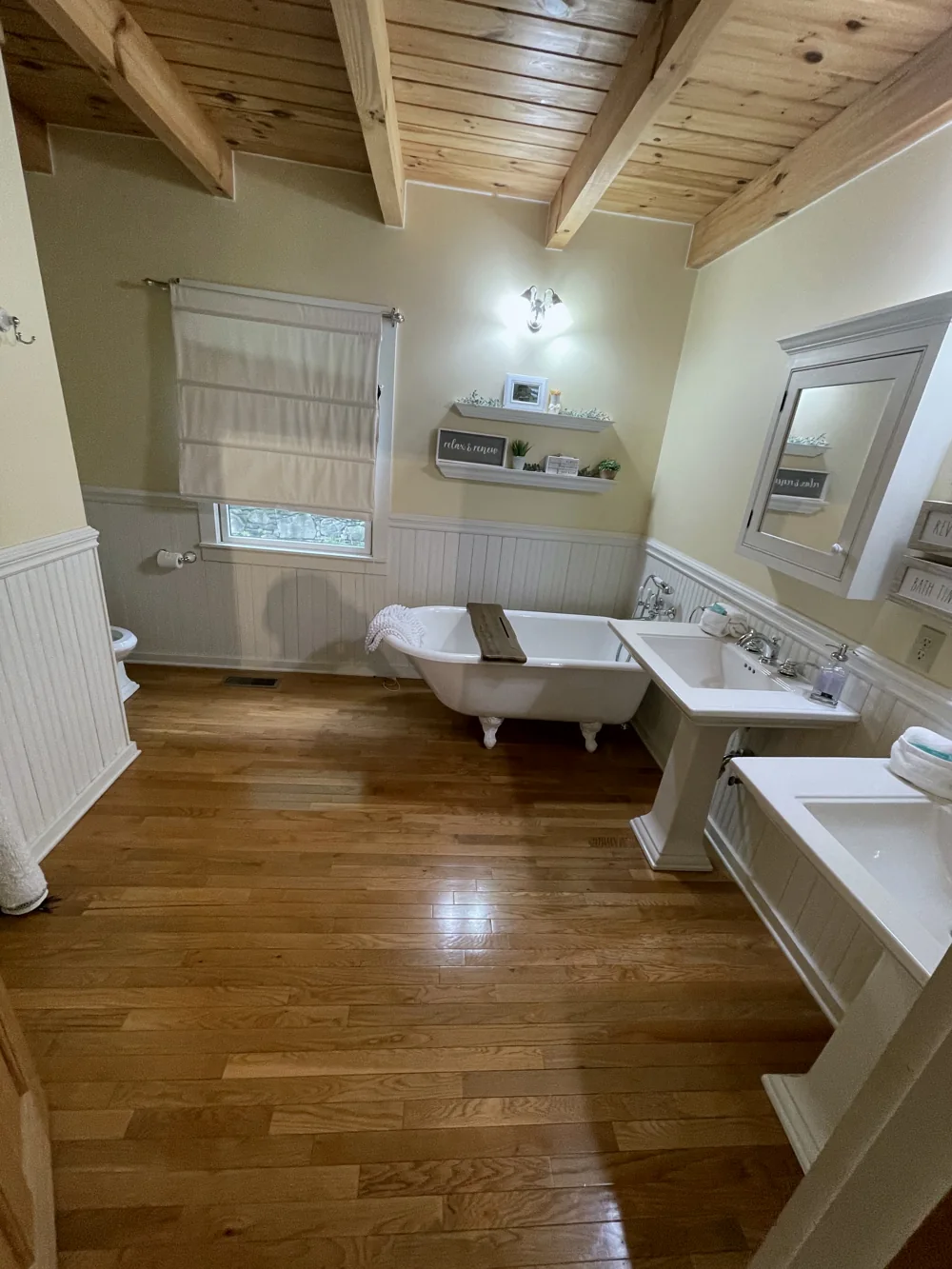 Bathroom with a white clawfoot bathtub and wood plank ceiling