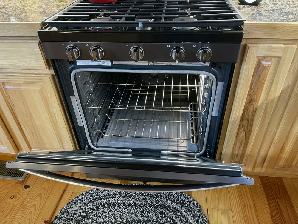 Open oven showing the interior, racks, and inner door
