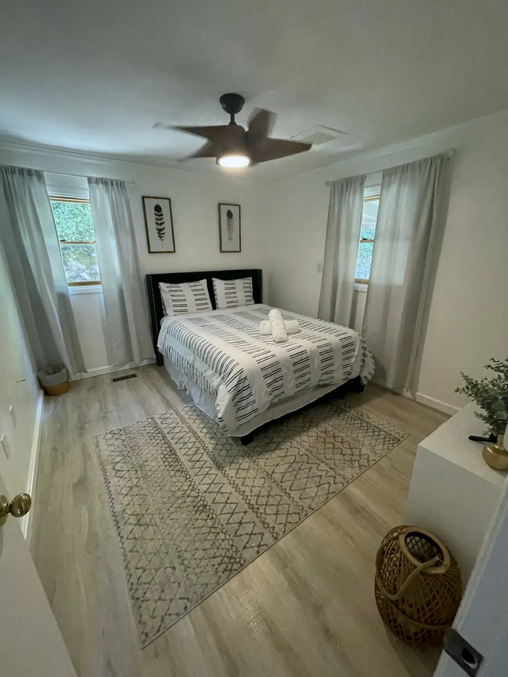 Guest bedroom with patterned bedding and a neatly arranged bed